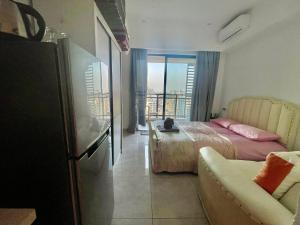 a bedroom with a bed and a couch and a window at U Mall Condo in Sihanoukville +9 photos