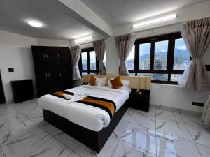 a bedroom with a large bed in a room with windows at Mandala Resorts & Events in Panepa +8 photos