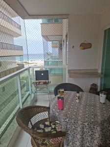 a balcony with a table and chairs and a laptop at Belíssimo Apto à Beira Mar in Arraial do Cabo