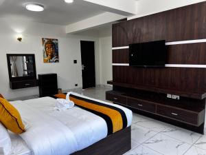 a bedroom with a large bed and a flat screen tv at Mandala Resorts & Events in Panepa