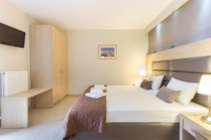 a hotel room with a bed and a television at Aroma Villa & Studios in Limenas +25 photos