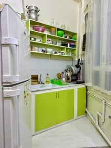 a kitchen with green cabinets and a white refrigerator at Appartement paisible in Tunis
