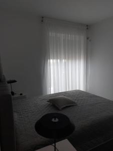 a bedroom with a bed with a table and a window at Romanescu Parc Apartment in Craiova