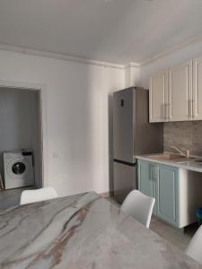 a kitchen with a table and chairs and a refrigerator at Romanescu Parc Apartment in Craiova
