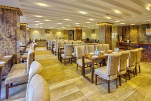 a restaurant with tables and chairs in a room at Hotel Katson Castle with Sunset View Dharamshala in Dharamshala
