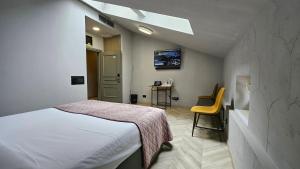 a bedroom with a bed and a table with a chair at Hotel Amfiteatar in Pula