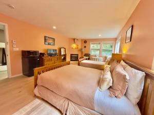 a bedroom with a large bed and a living room at Seafarer Bed & Breakfast in Tofino