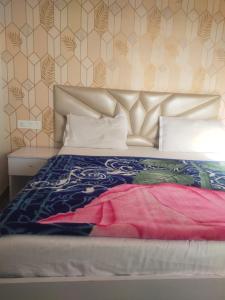 a bedroom with a bed with a bedspread on it at HideOut The Mall in Shimla