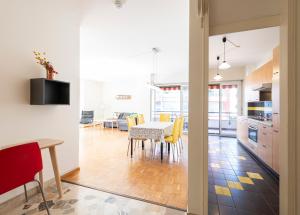 a kitchen and dining room with a table and yellow chairs at Hotel Atlantico self check-in in Lugano