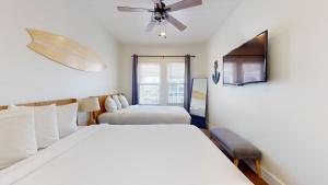 a bedroom with two beds and a ceiling fan at The Beach House in Ocean City +7 photos