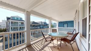 a patio with a table and chairs on a balcony at The Beach House in Ocean City