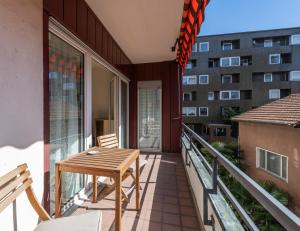 a balcony with a table and chairs and a building at Hotel Atlantico self check-in in Lugano