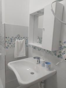 ein weißes Badezimmer mit Waschbecken und Spiegel in der Unterkunft Riama in Torralba