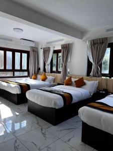 a room with three beds in it with windows at Mandala Resorts & Events in Panepa