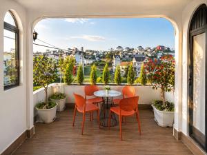 a balcony with a table and chairs and a view at Happy Life Hotel DaLat in Da Lat