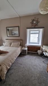 a bedroom with a large bed and a window at Penbryn Holidays, Barmouth in Barmouth