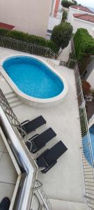 a swimming pool with lounge chairs next to a building at VILLA AURORA YourCroatiaHoliday in Savudrija