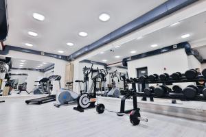 ein Fitnessstudio mit mehreren Laufbändern und Ergometern in der Unterkunft Fergana hotel in Fargʻona