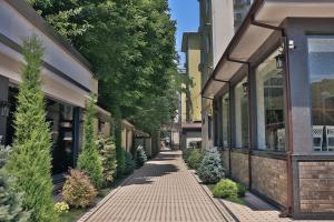 ein Gehweg vor einem Gebäude mit Bäumen in der Unterkunft Fergana hotel in Fargʻona