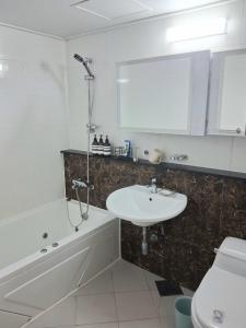 a bathroom with a sink and a tub and a toilet at 부산남포 프론트오션뷰 in Busan +19 photos