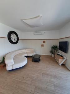a living room with a couch and a clock on the wall at VILA ROZA in Prožura