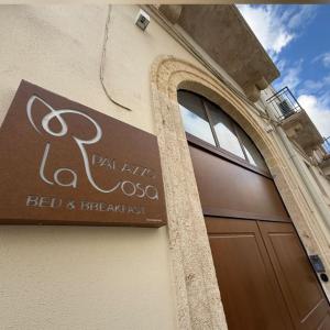 a sign on the side of a building with a door at B&B Palazzo La Rosa in Altamura +28 photos