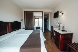 a bedroom with a bed and a table and a desk at Arcos de Montemar in Torremolinos +74 photos