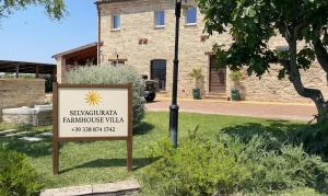 a sign in the grass in front of a building at SelvaGiurata Farmhouse Villa in San Benedetto del Tronto