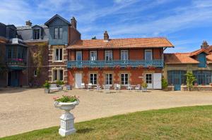 a large house with a vase of flowers in the yard at Chateau le Quesnoy in Chevrières