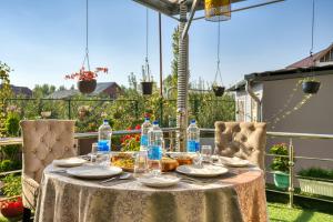 a table with plates and water bottles on a patio at The Montreal Srinagar A Unit Of Montreal Group in Srinagar
