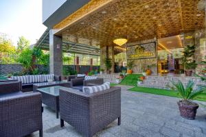 a patio with wicker chairs and tables in a building at The Montreal Srinagar A Unit Of Montreal Group in Srinagar