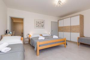 a hotel room with two beds and a chair at Bed and Breakfast Ema in Krk