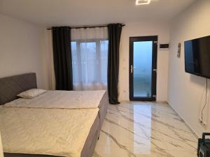 a bedroom with a bed and a flat screen tv at Villa Violand 2 in Limanu