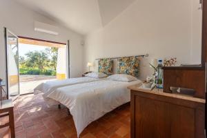 a bedroom with a large bed and a large window at Cerro da Campaniça in Santiago do Cacém +46 photos