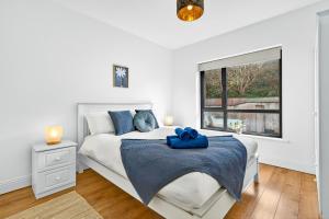 a white bedroom with a bed with a blue towel on it at Cnoc Na RI in Strandhill