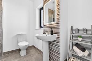 a bathroom with a white toilet and a sink at Cnoc Na RI in Strandhill +49 photos