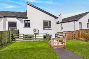 a white house with a fence and a yard at Cnoc Na RI in Strandhill