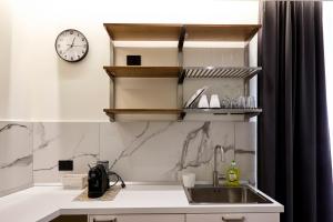 a kitchen with a sink and a clock on the wall at Palazzo delle Belle in Catania +99 photos