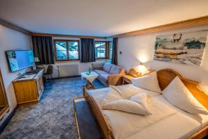 a living room with a couch and a tv at Pension Berger in Oberlech +16 photos