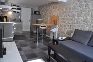 sala de estar con sofá y cocina en Gîte Le Moirantin, en Moirans-en-Montagne