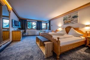 a bedroom with a large bed and a living room at Pension Berger in Oberlech