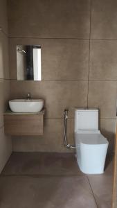 a bathroom with a white toilet and a sink at Noble Darshan in Guruvāyūr +57 photos