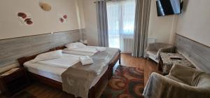 a hotel room with two beds and a chair at Pension Bittner in Braşov
