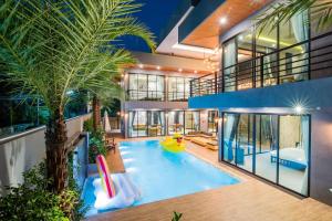 an indoor pool with a slide in a house at Playa Huahin by Ying in Hua Hin