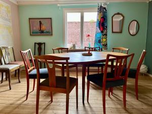 a dining room with a wooden table and chairs at Visseltofta old café - unexpected and picturesque in Osby