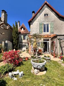 a house with a yard with sheep statues in front of it at Chambres d'Hôtes Colibri in Arthez-de-Béarn
