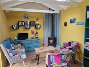 a living room with two chairs and a stove at Bramblewick House Glamping in Longford