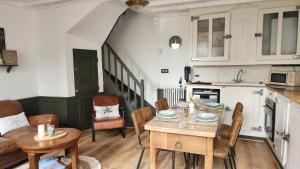 a kitchen and dining room with a table and chairs at Le Clos des Souvenirs in Étretat