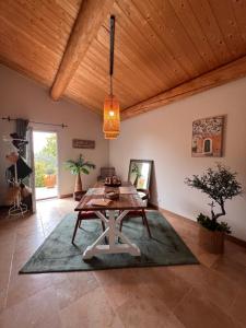 a dining room with a wooden ceiling and a table at La Bastide de Grosille in Savasse