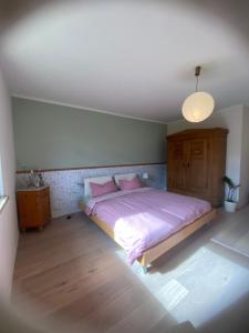 a bedroom with a large bed with pink pillows at Meyer im Moor in Grasberg